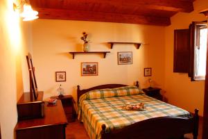 a bedroom with a bed with a plaid blanket at Fattoria Terra e Libertà in Contrada Maeggio +51 photos