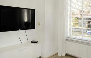 een flatscreen-tv op een witte muur naast een raam bij Lindegracht in Alkmaar