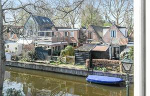 een groep huizen naast een rivier met een blauwe boot bij Lindegracht in Alkmaar