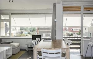 ベルゲン・アーン・ゼーにあるAwesome Apartment In Bergen An Zeeのテーブルと椅子と窓のあるリビングルーム