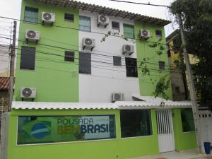 a green and white building with a sign in front of it at Pousada Bem Brasil in Macaé