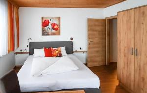 a bedroom with a bed with white sheets and red pillows at Ferienwohnung In Maria Luggau in Maria Luggau