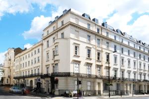 um edifício branco na esquina de uma rua em Prince William Hotel em Londres