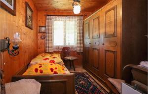 een slaapkamer met een bed in een houten kamer bij Lovely Home In Leutasch With Kitchen in Leutasch