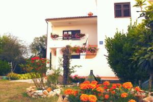 a white house with flowers in front of it at Apartment in Sisan - Istrien 41776 in Šišan