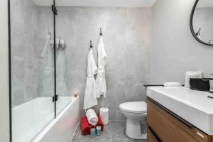 a bathroom with a tub and a toilet and a sink at Studio LIV203 by Gestion ELITE in Mont-Tremblant