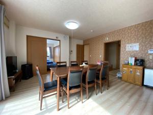 Angel Resort Karuizawa في كارويزاوا: غرفة معيشة مع طاولة طعام وكراسي