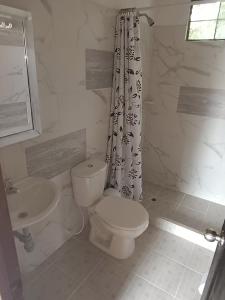 uma casa de banho branca com um WC e um lavatório em Hotel Villa Maritza em Melgar