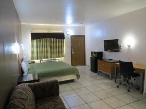 una camera d'albergo con letto e scrivania di Executive Inn Laguna Vista a Laguna Vista