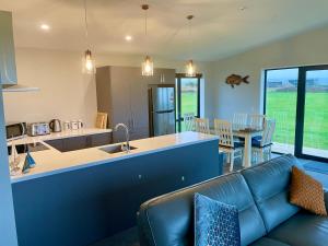 Glenledi的住宿－Toko Mouth Beach House，客厅以及带沙发和桌子的厨房。