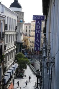 eine Gruppe von Menschen, die eine Stadtstraße entlang laufen in der Unterkunft Hostal Adriano in Madrid