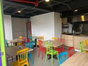 un comedor con mesas de madera y sillas coloridas en La posada de Rubi, en Salento