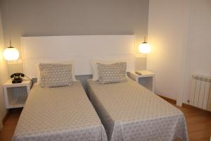 Łóżko lub łóżka w pokoju w obiekcie Hostal Adriano