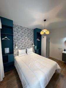a bedroom with a large white bed with a blue wall at Le 101 - Les Locations ISAHORA in Eu
