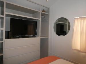 sala de estar con TV y espejo en LIV Resort: Clam Circle with Private Jacuzzi (Pet Friendly) en Port Isabel