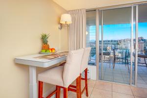 a kitchen with a table and chairs and a balcony at Stylish Studio with Great Ocean Views & Near Beach! in Honolulu