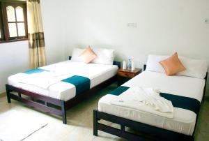 - une chambre avec 2 lits et une table dans l'établissement The Blue Mountain Resort, à Bandarawela