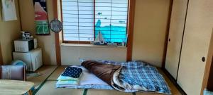 秩父市にあるきっとあい楽館のベッドと窓が備わる小さな客室です。