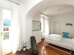 a white bedroom with a bed and a window at B&B villa sempreverde in Locarno