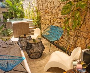 a patio with furniture and a stone wall at Les Suites Calle 2 by Galian in Tulum