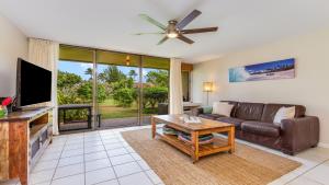 a living room with a couch and a flat screen tv at Beach Cozy North Shore Turtle Bay Condo in Kahuku