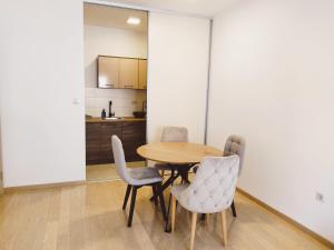 una sala da pranzo con tavolo e sedie di Aura City Apartment a Podgorica