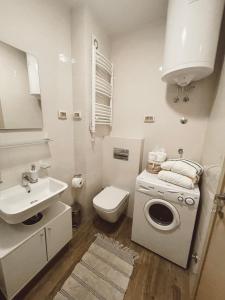 bagno bianco con lavandino e lavatrice di Aura City Apartment a Podgorica