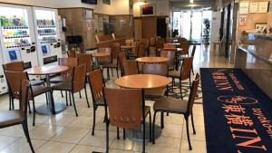 Toyoko Inn Matsumoto Ekimae Hommachi في ماتسوموتو: غرفة طعام مع طاولات وكراسي في مطعم