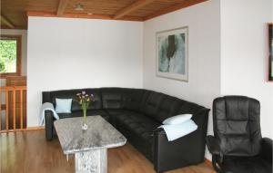 a living room with a black leather couch and a table at Lovely Home In Sandnes With Sauna in Idse +7 photos