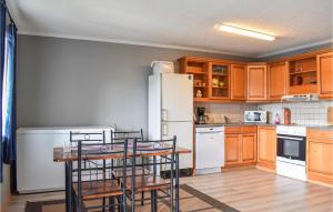 a kitchen with a white refrigerator and wooden cabinets at Nice Apartment In S-4275 Svelandsvik With Kitchen in Sæveland