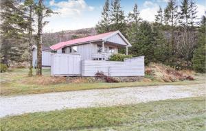 ein weißes Haus mit einem Zaun vor einer Straße in der Unterkunft 3 Bedroom Lovely Home In Helvik in Egersund
