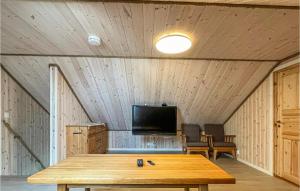 Habitación con mesa y TV en el techo. en 5 Bedroom Amazing Home In Nedstrand en Nedstrand