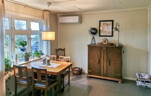a dining room with a wooden table and a cabinet at 3 Bedroom Awesome Home In Finns in Kuleseid