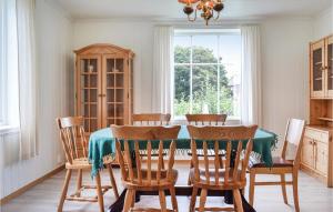 uma sala de jantar com uma mesa e cadeiras e uma janela em Amazing Home In Urangsvg With House A Panoramic View em Bømlo
