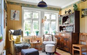 ein Wohnzimmer mit 2 Stühlen und einem Fenster in der Unterkunft Amazing Home In Hylandsbygd With House Sea View 