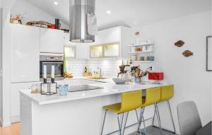 una cocina con encimeras blancas y sillas amarillas en Gorgeous Home In Stolmen With Kitchen, en Våge