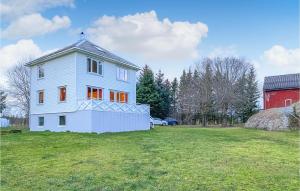 a white house with orange windows on a field at Amazing Home In Hary With House Sea View in Steinshamn