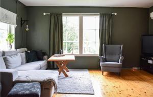 salon z kanapą, stołem i oknem w obiekcie Nice Home In Tysse With House A Panoramic View w mieście Bjørkheim
