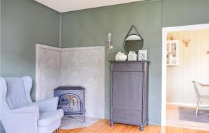 a living room with a chair and a fireplace at Beach Front Home In Tysse With Wifi in Bjørkheim