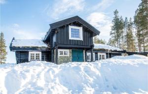 a house covered in snow with a pile of snow at Nice Home In stby With Wifi And 4 Bedrooms in Østby