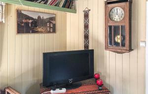 a television sitting on a table next to a clock at 1 Bedroom Cozy Home In Vinstra in Vinstra