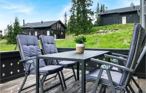 a table and chairs on a deck with a house at Gorgeous Home In Sjusjen With House A Mountain View in Sjusjøen