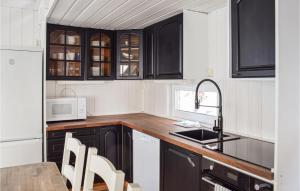 a kitchen with black cabinets and a sink at Alpinhytte 2 in Favang