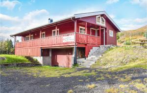 a red barn with a red door on a hill at Stunning Home In Vatne With 3 Bedrooms in Vatne