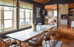 SjusjøenにあるStunning Home In Sjusjen With Wifiのリビングルーム(木製テーブル、椅子付)