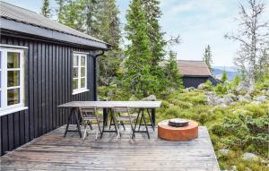 a wooden deck with a table and chairs on a house at Nice Home In Sjusjøen With Wifi in Sjusjøen +14 photos