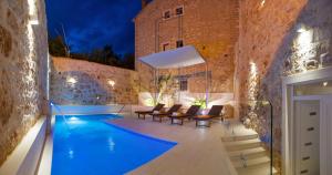 una piscina en una habitación con sillas y un edificio en Villa Majestic with heated pool and rooftop terrace, en Bol