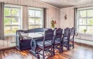 a dining room with a table and chairs and windows at Lovely Home In Sjusjen With Wifi in Sjusjøen