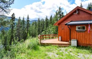 eine Holzhütte mit einer Terrasse im Wald in der Unterkunft Lovely Home In Espedalen With Kitchen in Espedalen