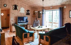 a living room with a couch and a table and a tv at Lovely Home In Espedalen With Kitchen in Espedalen